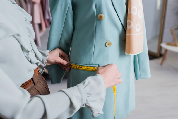 Vista recortada del bolsillo de medición costurera de la chaqueta en el atelier  - Foto, Imagen