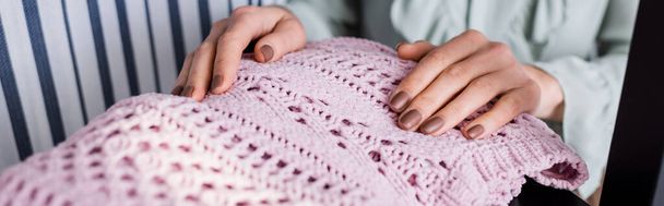 Cropped view of seamstress touching sweater in atelier, banner  - Foto, imagen