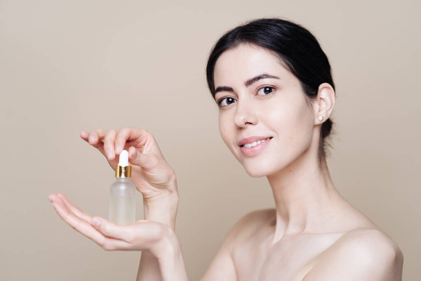 Caucasian woman holding bottle with serum - Photo, Image
