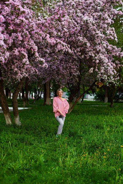 Bella signorina nel giardino dei fiori di ciliegio - Foto, immagini