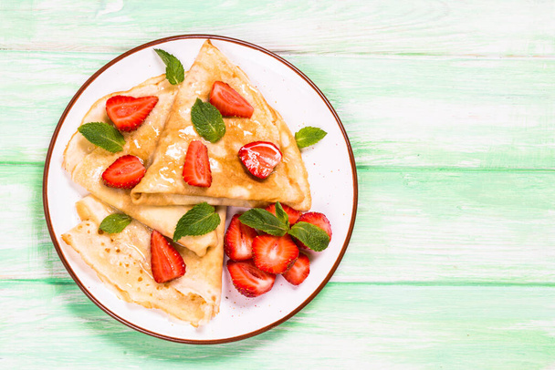 Crepes with fresh srawberries and honey. - Photo, Image
