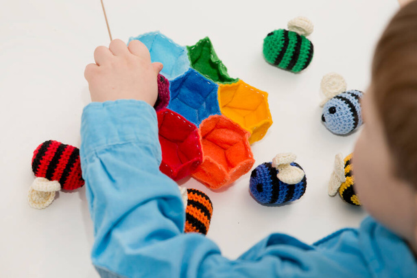 Красочный улей с пчелами. Вязаные безопасные игрушки для детей. Обработанные идеи яичного ремесла - это яркая радужная образовательная игрушка пасхального цвета. Дошкольная игра для маленьких детей. Монтессори - Фото, изображение