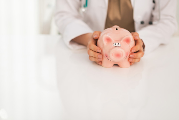 Medical doctor holding piggy bank - Foto, Imagem