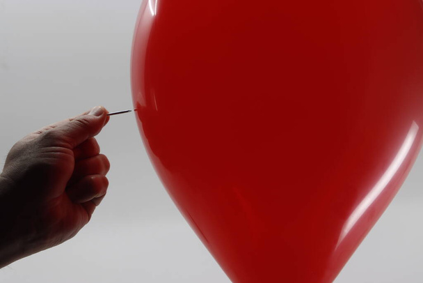 Nadel in der Nähe eines roten Ballons - Foto, Bild