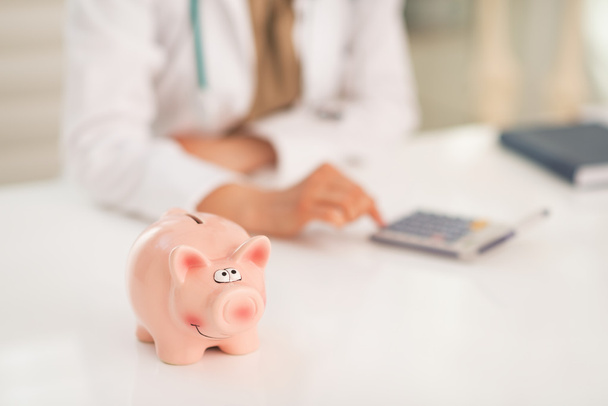 Piggy bank and medical doctor woman - Фото, зображення