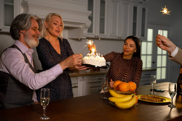 Grootvader viert zijn verjaardag met taart, kaarsen en sterretjes - Foto, afbeelding