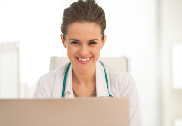 Smiling medical doctor using laptop - Φωτογραφία, εικόνα