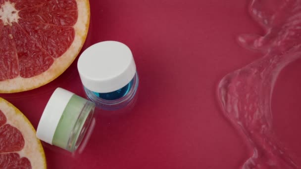 Pienet kosmeettiset purkit ihonhoitotuotteilla silmille puhtaan veden roiskeissa - Materiaali, video