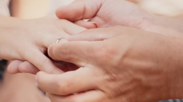Engagement concept. Close up shot of man putting diamond ring on female finger and stroking her - Footage, Video