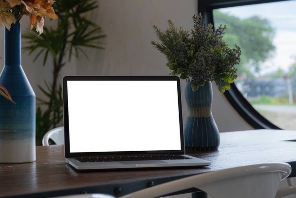 Kahve dükkanındaki ahşap masada dizüstü bilgisayar beyaz ekranı. Bağımsızlık ve her yerden çalışma kavramı. - Fotoğraf, Görsel