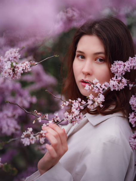 hermosa joven asiática mujer disfrutando de la floración de flores en primavera. Maquillaje desnudo. Primer plano retrato - Foto, Imagen