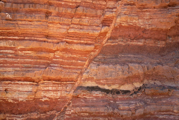 İsrail, Eilat yakınlarındaki Kızıl Kanyon 'da katmanlarında hataları olan kırmızı tortulu kayalar.. - Fotoğraf, Görsel