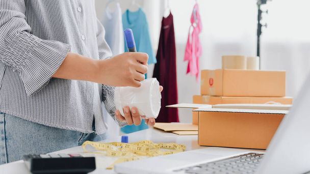 Closeup view of female online store small business owner seller entrepreneur packing package post shipping box preparing delivery parcel on table. entrepreneurial self employed business concept. - Foto, Imagen