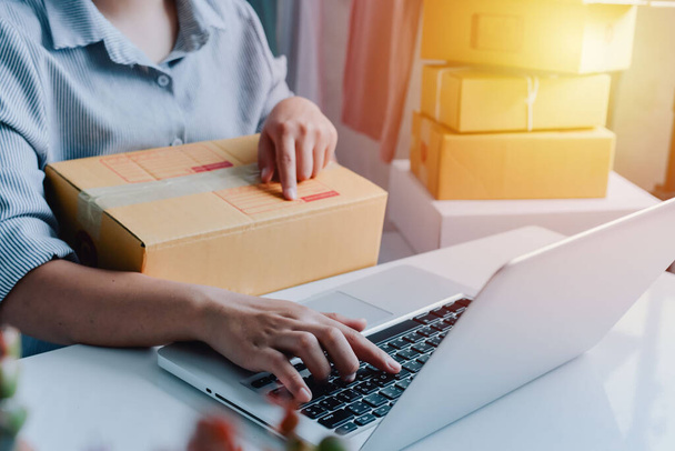 Closeup view of female online store small business owner seller entrepreneur packing package post shipping box preparing delivery parcel on table. entrepreneurial self employed business concept. - Photo, Image