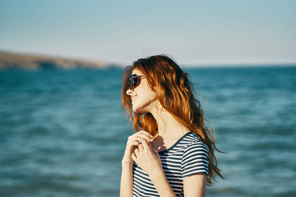 Reiziger in T-shirts en in zonnebril bij zee en bergen op de achtergrond - Foto, afbeelding