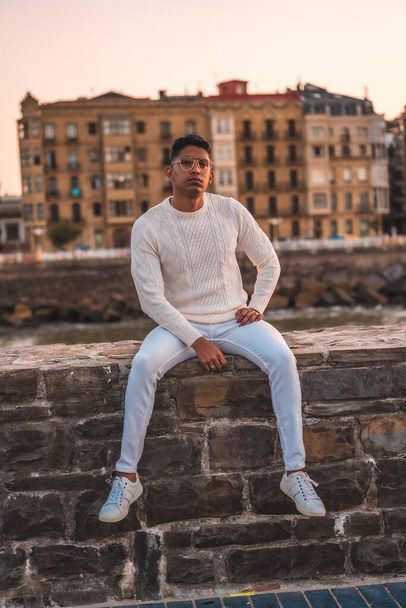 Summer lifestyle, a young Latino enjoying summer vacations. dressed in white with pants and sweater - Fotografie, Obrázek