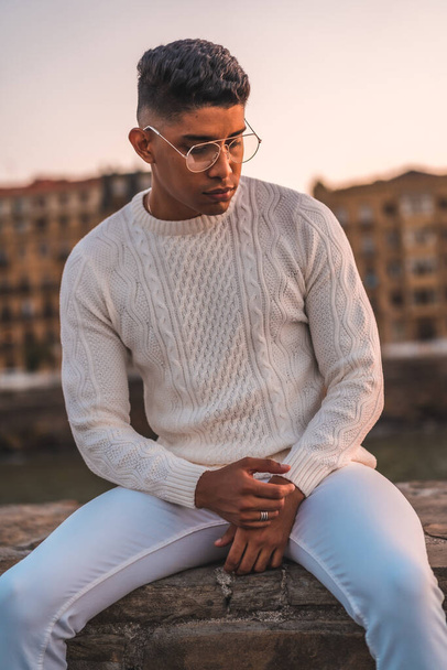 Summer lifestyle, a young Latino enjoying summer vacations. dressed in white with pants and sweater - Fotó, kép