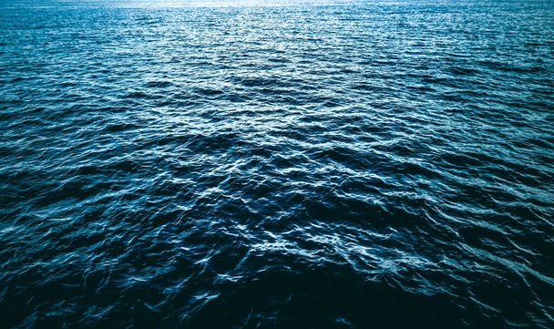 Diepblauwe oceaan water textuur, donkere zee golven achtergrond als natuur en milieu-ontwerp - Foto, afbeelding