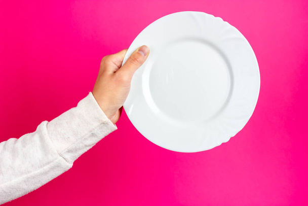 White ceramic plate in a womans hand. Empty ceramic plate. - Fotoğraf, Görsel