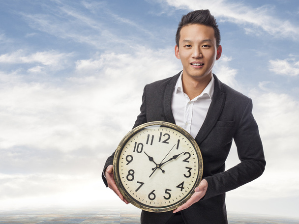 Hombre de negocios sosteniendo reloj
 - Foto, imagen