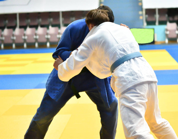 Deux garçons judoka en kimono rivalisent sur le tatami  - Photo, image