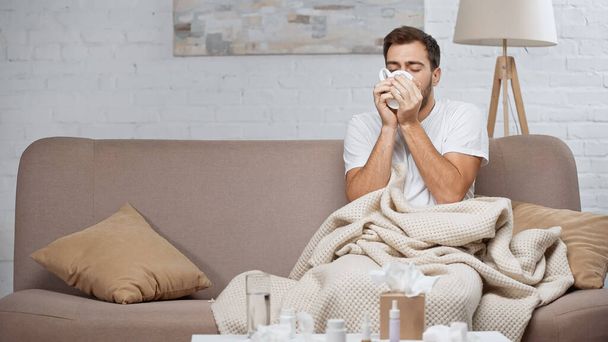 diseased man drinking tea while sitting on couch  - Foto, Imagem