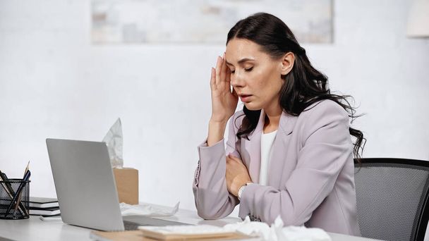 allergic businesswoman having headache near laptop on desk - 写真・画像