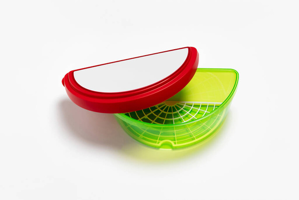 Kunststoffbehälter für Wassermelonenscheibe. Wassermelonenschoner mit abnehmbarem Tablett auf weißem Hintergrund. Hochauflösendes Foto. - Foto, Bild