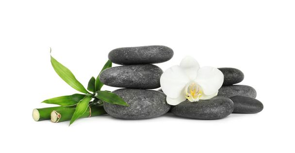Spa stones, beautiful orchid flower and bamboo stems on white background - Foto, Imagem