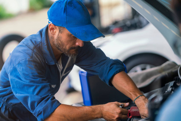 Araba tamiri. Otomobil tamircisi ingiliz anahtarıyla çalışıyor. Tamirci işte.  - Fotoğraf, Görsel