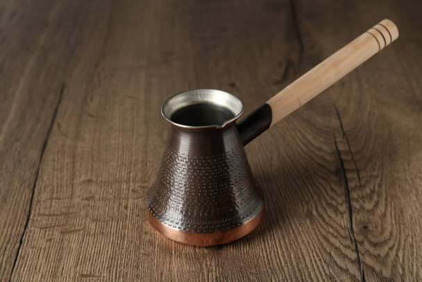 Copper turkish coffee pot on wooden table - Zdjęcie, obraz