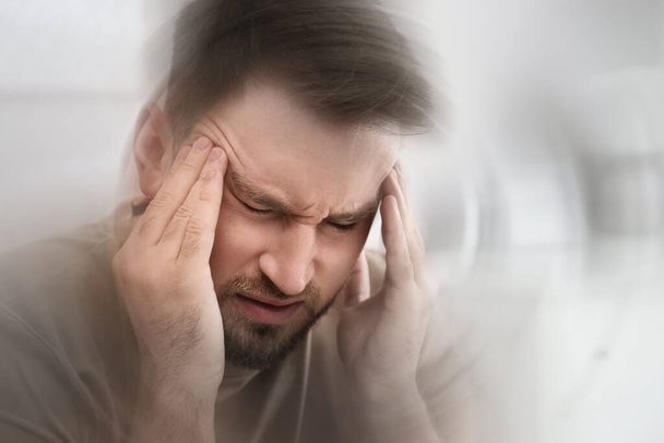 Młody mężczyzna cierpiący na migrenę w domu, zbliżenie - Zdjęcie, obraz