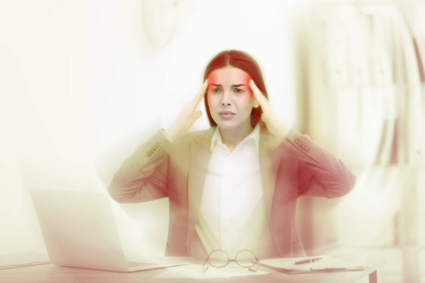 Woman suffering from migraine at workplace in office - Fotoğraf, Görsel