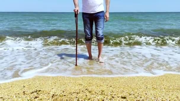 Disabled person with a cane comes out of the sea - Footage, Video