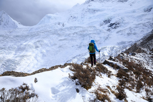 Successful woman backpacker hiking in winter mountains - Fotografie, Obrázek