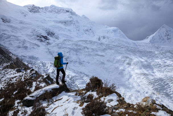 Successful woman backpacker hiking in winter mountains - Fotografie, Obrázek