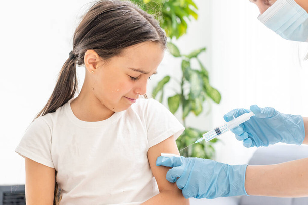 pielęgniarka szczepiąca małą dziewczynkę - Zdjęcie, obraz