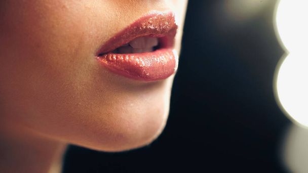 唇に光沢のあるリップグロスで官能的なモデルのクロップドビュー - 写真・画像