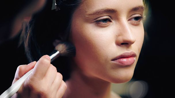 makeup artist applying  face powder on brunette woman  - Foto, Imagen
