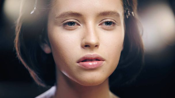 close up of young brunette woman with face foundation looking away - Fotoğraf, Görsel