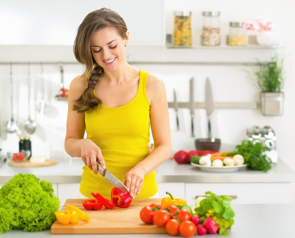 Young woman cutting fresh vegetables - Foto, imagen