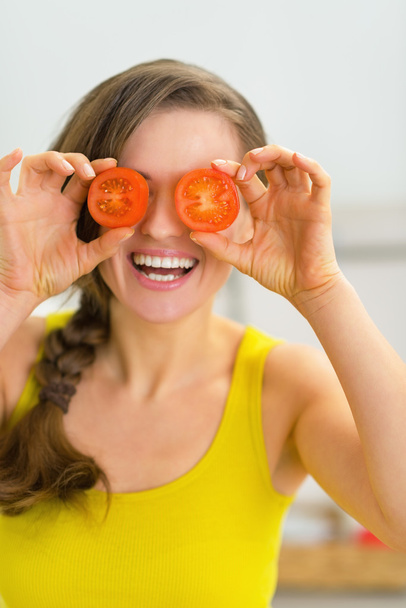 γυναίκα που κρατά τις φέτες ντομάτας μπροστά στα μάτια - Φωτογραφία, εικόνα