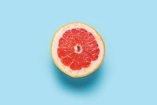 Půl grapefruitu na modrém pozadí. Detailní záběr. Koncept letní pozadí, tapety. Banner. Byt ležel, horní pohled. - Fotografie, Obrázek