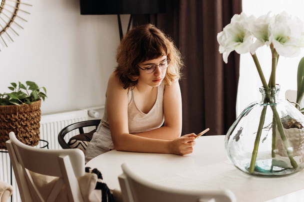 Молода дівчина читає погані новини по телефону. Підліток дивиться сумне відео на смартфон
 - Фото, зображення