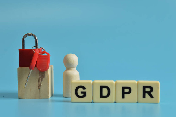 Padlock, keys, wooden figure and alphabet letters with text GDPR stands for General Data Protection Regulation. - Valokuva, kuva