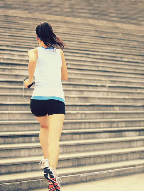 Runner athlete running on stairs listening to music - Фото, изображение