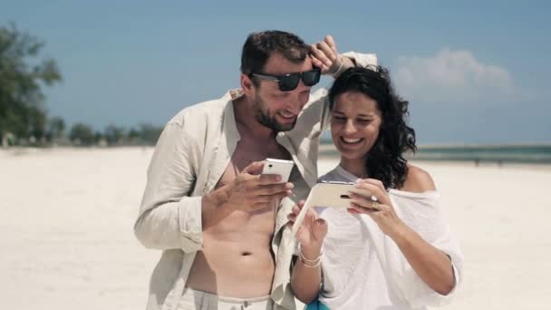 Couple with smartphone on beach - Кадры, видео