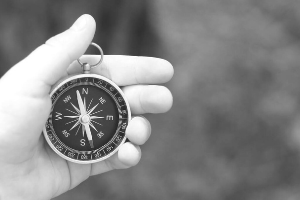 Alter klassischer Navigationskompass in der Hand auf natürlichem Hintergrund als Symbol des Tourismus mit Kompass, Reisen mit Kompass und Outdoor-Aktivitäten mit Kompass - Foto, Bild