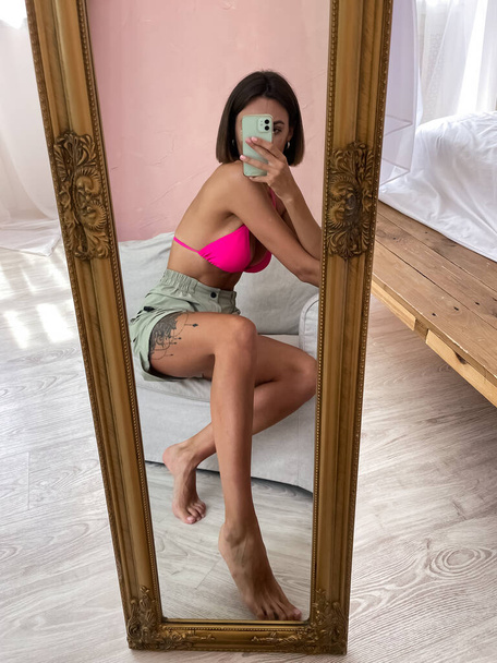 Sopiva ruskettunut nainen täydellinen elin, abs, shortsit ja bikinit, ottaa valokuvan selfie puhelimessa peilissä kotona sosiaalisen median, tarinoita, pystysuora - Valokuva, kuva