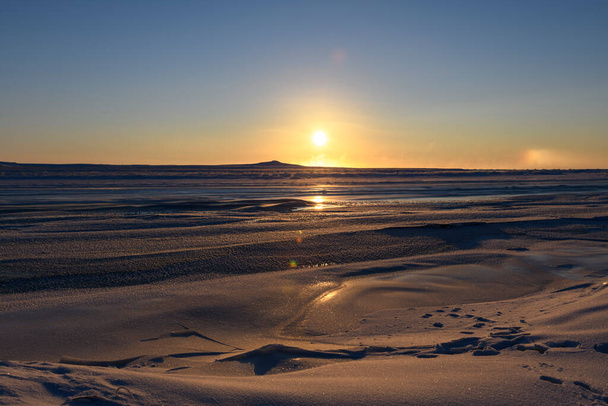 Arctic landscape in winter time. Small river with ice in tundra. Sunset. - Photo, Image